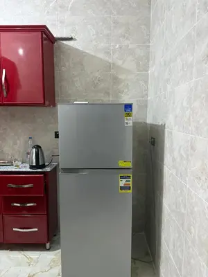 a white refrigerator in a kitchen with a red cabinet at Marco inn in Amman