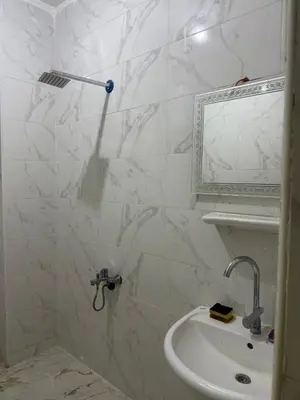 a white bathroom with a sink and a mirror at Marco inn in Amman