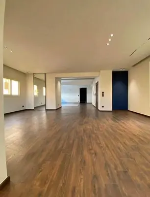 an empty room with a wooden floor in a building at Jordan farm in Amman
