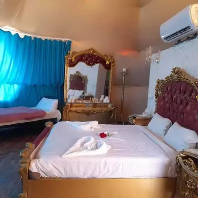 a bedroom with a large bed with a mirror at Wadi rum sami camp in Wadi Rum