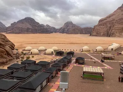 a view of a desert with tents and mountains at Wadi rum sami camp in Wadi Rum
