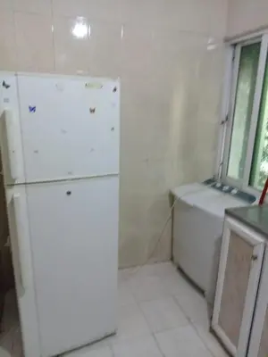 a kitchen with a white refrigerator and a window at Al Martini Building Number 11 in Amman