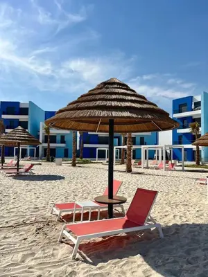 a group of chairs and an umbrella on a beach at واحة ايلة ازور in Aqaba