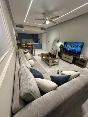 a living room with a large couch and a tv at واحة ايلة ازور in Aqaba