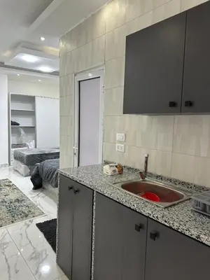 a kitchen with a sink and a room with a bed at Omar rent apartments in Amman