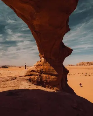 a man standing next to a rock in the desert at Spirit of the Badia camp in Disah