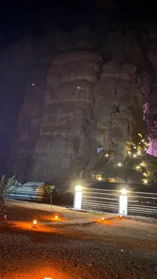 a rock wall at night with lights in front of it at Spirit of the Badia camp in Disah