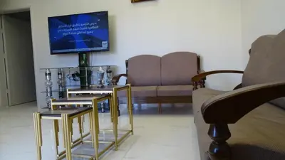 a living room with a couch and a tv at Petra Luminous Apartment in Wadi Musa