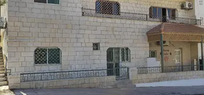 a brick building with a door and a balcony at Petra Luminous Apartment in Wadi Musa