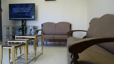 a living room with two couches and a television at Petra Luminous Apartment in Wadi Musa