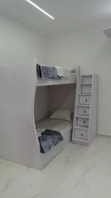 a white room with two bunk beds in it at Petra Luminous Apartment in Wadi Musa