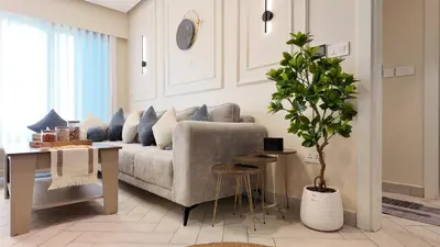 a living room with a couch and a potted tree at واحة ايلة ازور in Aqaba