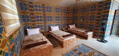 a room with two beds and a couch in it at Wadi Rum Aura Camp in Wadi Rum