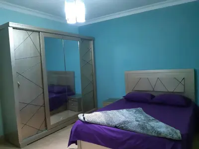 a bedroom with a purple bed and a glass cabinet at Amman house in Amman