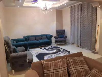 a living room with a couch and two chairs at Amman house in Amman