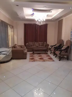 a living room with couches and a chandelier at Amman house in Amman