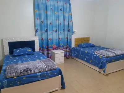 a bedroom with two beds and a curtain at Amman house in Amman