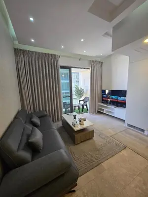 a living room with a couch and a coffee table at Pasha House - DAMAC Tower in Amman