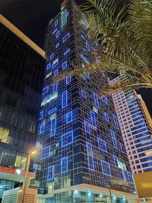 a tall building with blue lights on it at Pasha House - DAMAC Tower in Amman