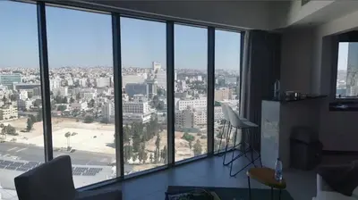 a living room with a view of a city at Pasha House - DAMAC Tower in Amman