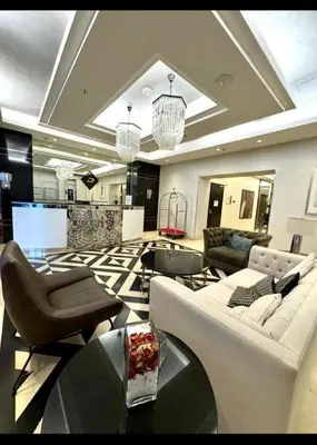 a living room with couches and chairs and a table at Pasha House - DAMAC Tower in Amman