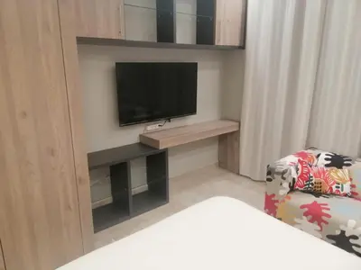 a living room with a television and a chair at Pasha House - DAMAC Tower in Amman