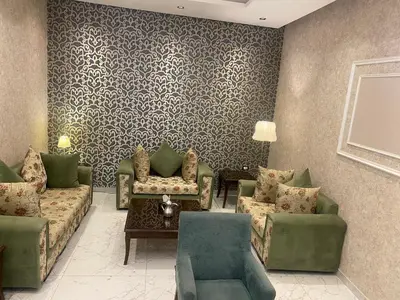 a living room with couches and chairs and a table at Petra night hostel in Wadi Musa