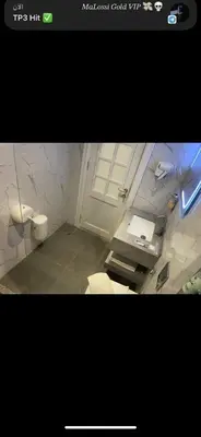 a bathroom with a toilet and two sinks and a window at Petra night hostel in Wadi Musa