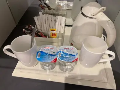 a shelf in a refrigerator with two cups and a tea pot at Petra night hostel in Wadi Musa