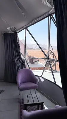 a purple chair in a room with a view of the desert at Bedouin Luxe Camp & Tour in Wadi Rum
