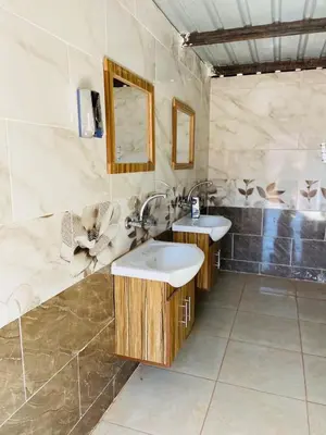 a bathroom with two sinks and a mirror at Sunrise Magic Camp in Wadi Rum