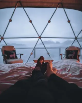 a person laying on a bed with their feet up at Rum marea in Disah