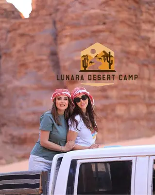 two women standing in the back of a truck at Lunara Desert Luxury Camp in Wadi Rum