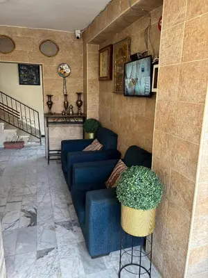 a living room with a blue couch and a table at New Hamoudeh Hotel in Amman