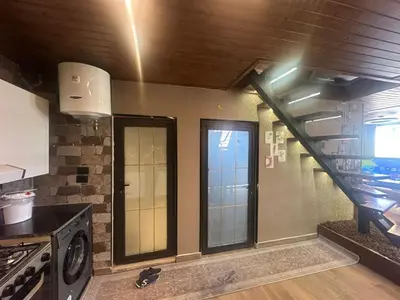 a kitchen with a staircase and a stove at Umm Aljulud Cottages 01 in Ajloun
