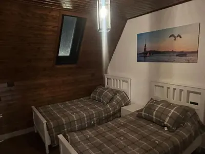 a bedroom with two beds and a window and a picture at Umm Aljulud Cottages 01 in Ajloun