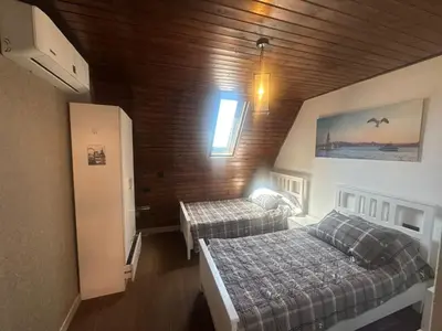 a bedroom with two beds in a room with wooden walls at Umm Aljulud Cottages 01 in Ajloun