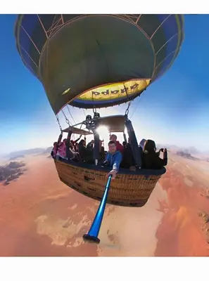 a man riding a hot air balloon over a desert at Wadi rum tenda camp in Wadi Rum