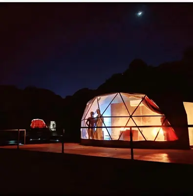 a person standing inside of a greenhouse at night at Wadi rum lona camp in Wadi Rum