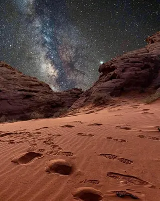 a starry night with footprints in the sand in a desert at Wadi rum lona camp in Wadi Rum