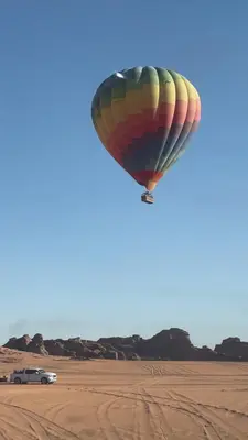 a hot air balloon flying over the desert at Nomads Heaven in Disah