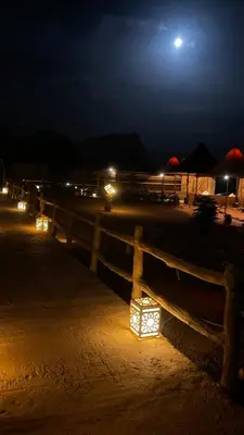 a wooden fence with lights on it at night at Nomads Heaven in Disah