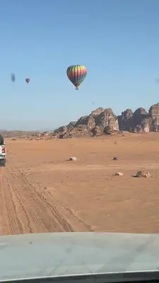 a hot air balloon flying over the desert at Nomads Heaven in Disah