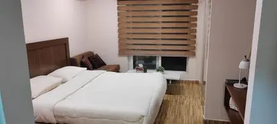 a bedroom with a white bed and a window at Fully furnished studio in Amman
