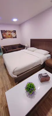 a bedroom with a large bed and a table at Fully furnished studio in Amman