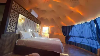a bedroom with a bed and a ceiling with lights at Wadi rum naef camp in Wadi Rum