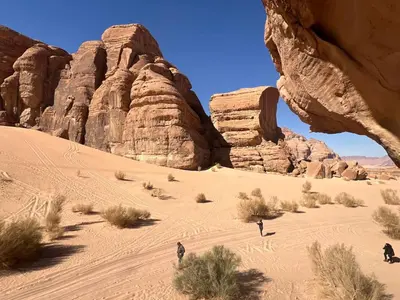 a group of people walking through the desert at Wadi rum naef camp in Wadi Rum