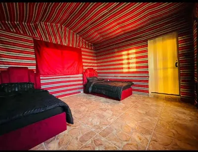a room with two beds and a red and white striped ceiling at Dana Sunset camp in Nijil