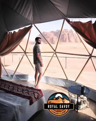a man standing in a pyramid tent in the desert at ROYAL SAVOY lUXURY CAMP in Wadi Rum