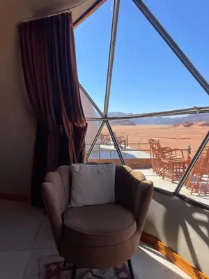 a chair in a room with a large window at NOVA lUXURY CAMP in Wadi Rum
